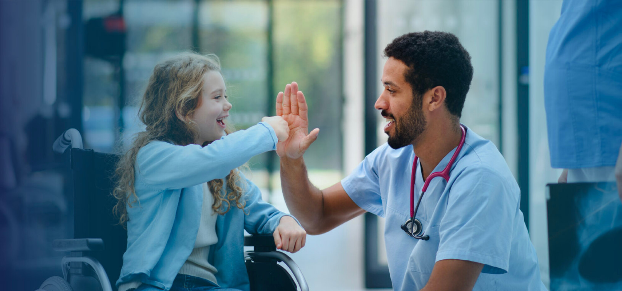 Doctor high fiving a girl in wheelchair